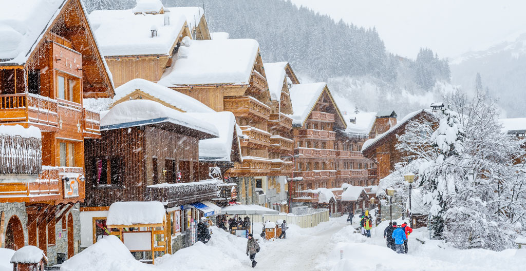 Gros plan sur la texture du bois vieilli d'un balcon traditionnel de chalet savoyard avec détails sculptés et fer forgé